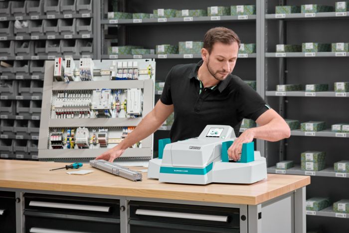 Person removing marked card materials from the UV inkjet printer