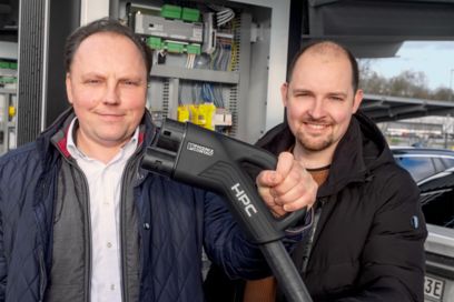 Two employees with the new HPC charging cable
