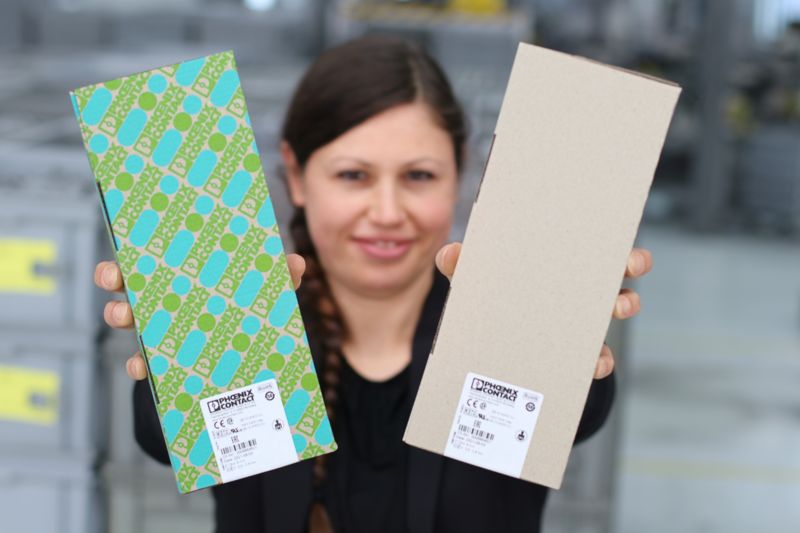 Employee showing the colorful and gray packaging side by side