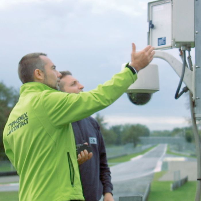 Installers check the camera junction box of a video surveillance camera for traffic
