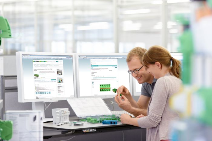 Des collaborateurs regardent les produits de Phoenix Contact sur des écrans