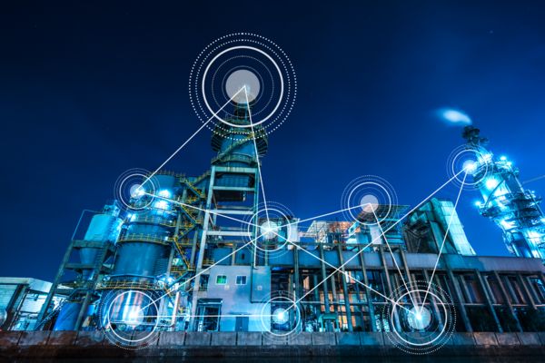 Illuminated industrial system at night with networking symbols