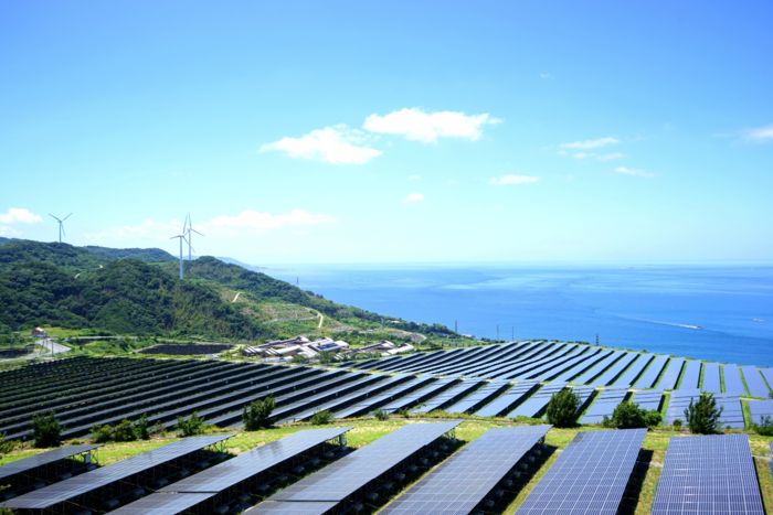 Paneles solares con aerogeneradores al fondo