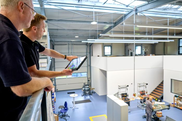 Phoenix Contact consultants in conversation at PGA Automation with a view of the production hall