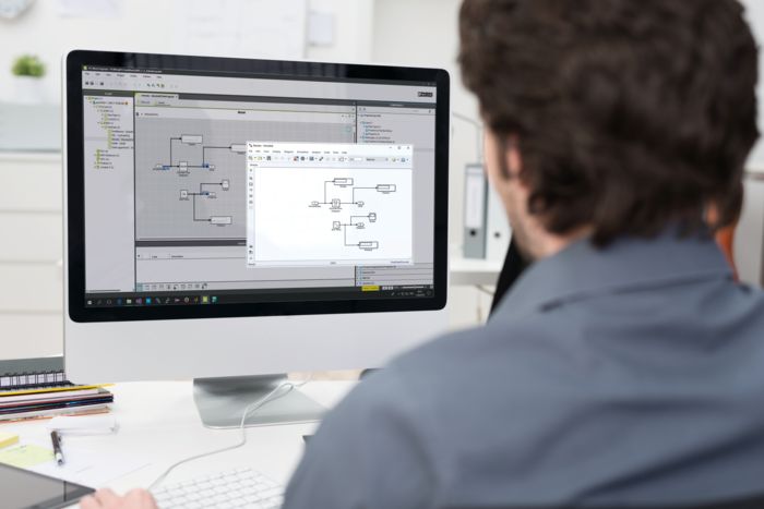 Man in front of monitor while modeling a wind turbine generator in Matlab Simulink