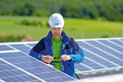 Technician surrounded by solar panels checks connection technology