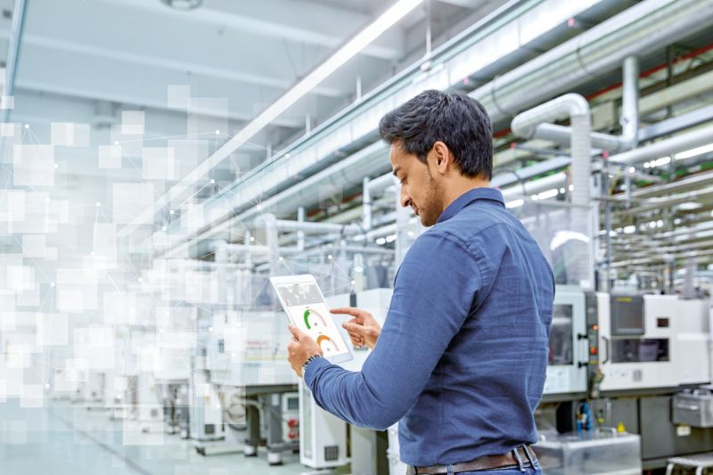 Person with a tablet in an industrial hall