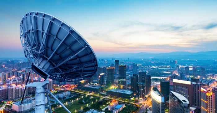Antenna parabolica su una montagna davanti a una città