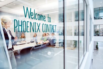 Büro mit Aufschrift Welcome to Phoenix Contact auf Glastür