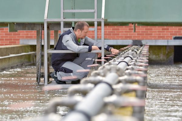 Osoba w oczyszczalni ścieków przy mechanicznym oczyszczaniu wstępnym