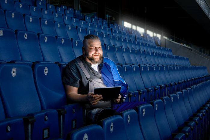 Mann steuert Beleuchtung im Stadion über ein Tablet