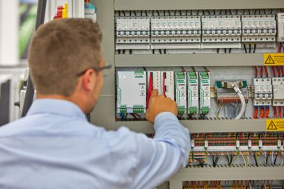 Une personne devant l'armoire électrique vérifie les réglages lorsque le disjoncteur CBM est installé