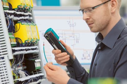 Person holding the CRIMPHANDY portable automatic stripping and crimping device and a wire in their hand 