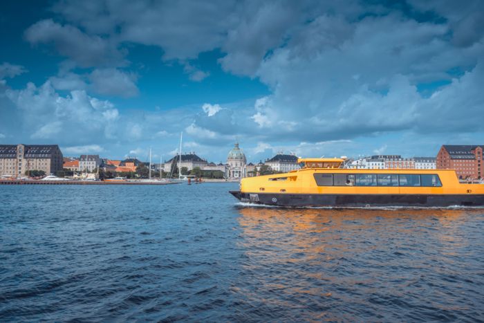 Ferry for passenger transport in Copenhagen on the river with the city in the background