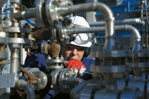 Personne effectuant des travaux de maintenance sur des tuyauteries dans une installation de process