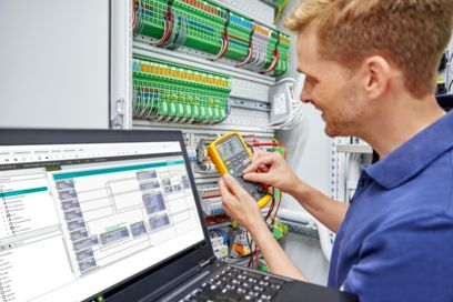 People in front of a control cabinet discussing the system integration