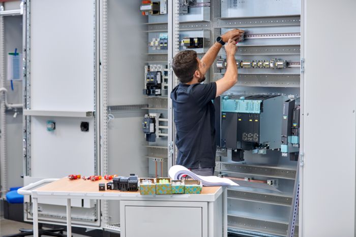 Un homme construisant une armoire électrique