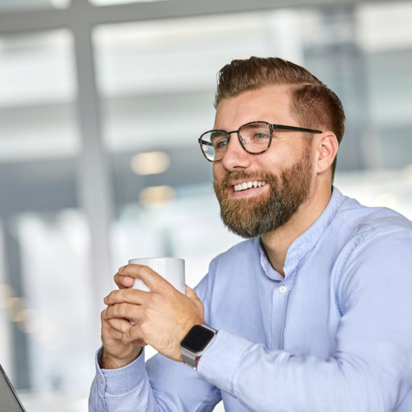 Mitarbeiter schaut in die Ferne und lächelt 