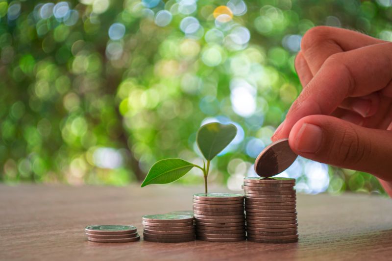 Hand legt Münzen auf einen Stapel