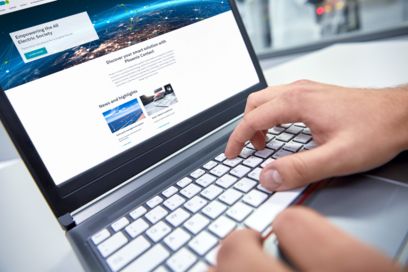 Un uomo al computer consulta online la gamma di prodotti Phoenix Contact