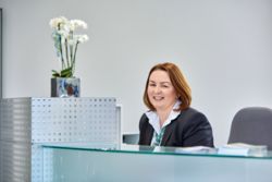 Eine Mitarbeiterin vom Empfang blickt in die Kamera