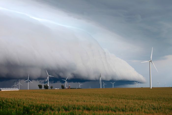 Windräder auf einem Feld mit schweren Wolken