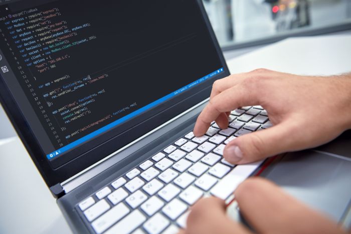 Mains sur le clavier d'un ordinateur portable