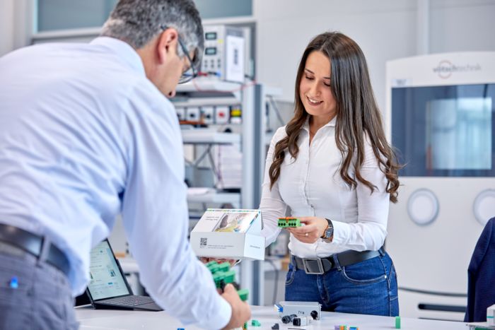 Un collaborateur de Phoenix Contact et une cliente avec un échantillon de produit