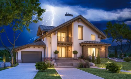 Illuminated house with lightning in the background