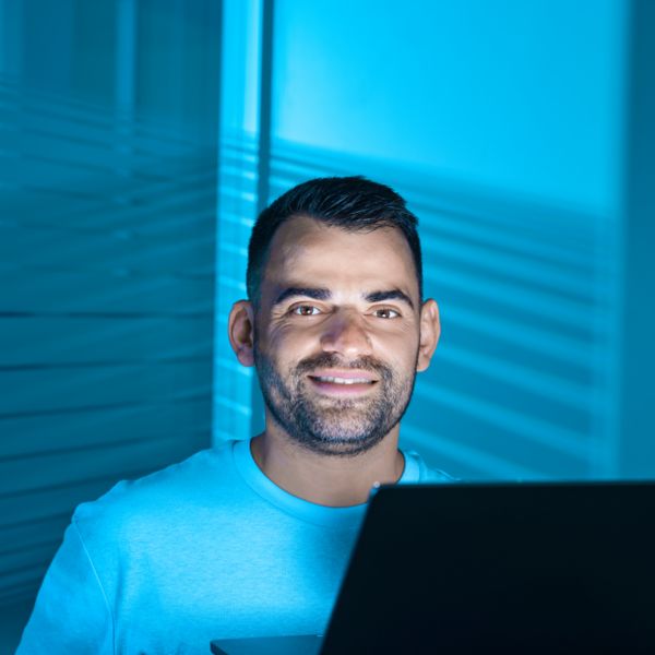 Person sitzt vor einem Laptop-Bildschirm