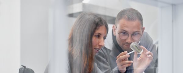 Twee mensen bekijken een onderdeel van dichtbij