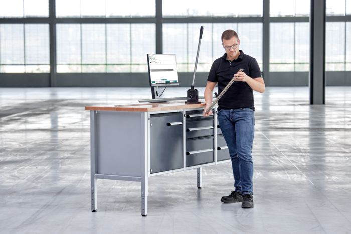 Cortador de trilho de fixação e monitor com o software de assistência ao operador em uma mesa de trabalho
