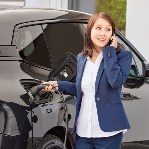 Une personne charge sa voiture électrique avec le câble de charge AC CHARX connect eco