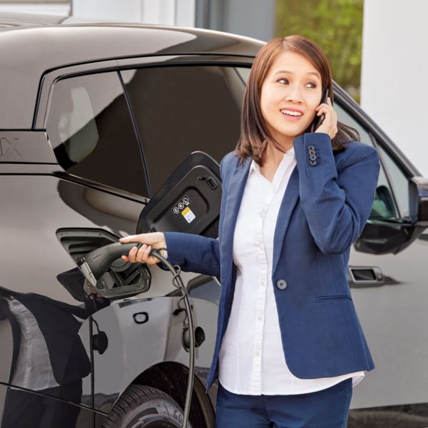 Uma pessoa carrega o veículo elétrico com o cabo de carga AC CHARX connect eco