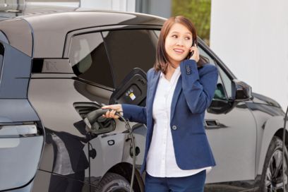 Woman charging an electric car at a fast charging station