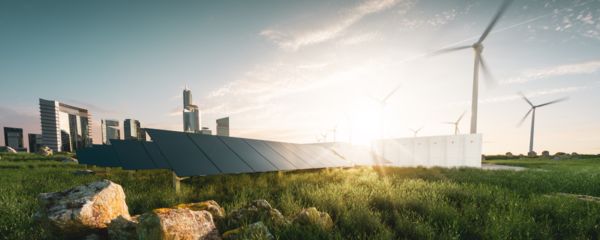 Rahmenlose Solarmodule, Batteriespeicher, Windräder und Großstadt mit Wolkenkratzer im Hintergrund.