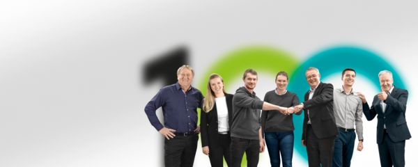 Medewerker van Phoenix Contact staat voor het logo van 100 jaar Phoenix Contact