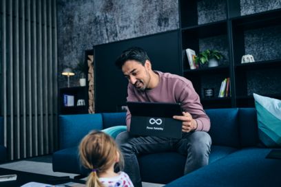 Mitarbeiter arbeitet im Home Office und schaut sein Kind an