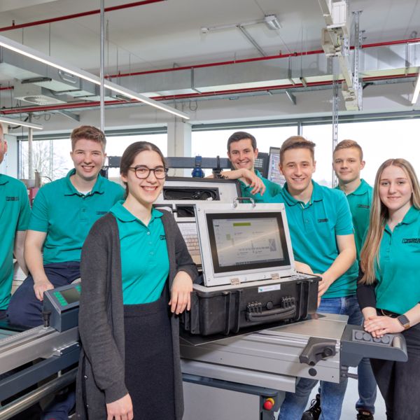 Eine Gruppe junger Mensch ist um ihr Studentenprojekt versammelt