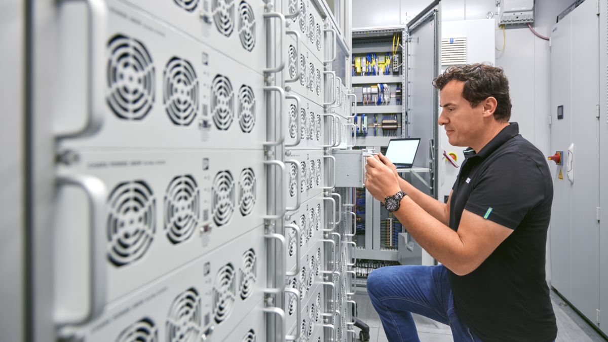 Person installing DC rectifier module in the control cabinet