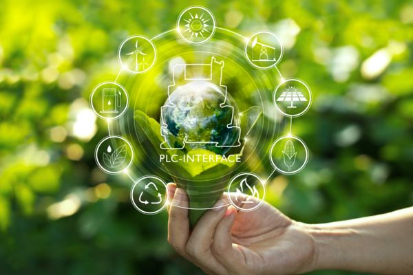 Kestävä kehitys esitettynä symboleina, jotka leijuvat käden yläpuolella, jossa on maapallo ja releitä