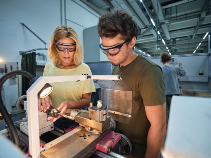 Mitarbeitende arbeiten zusammen an einer Maschine