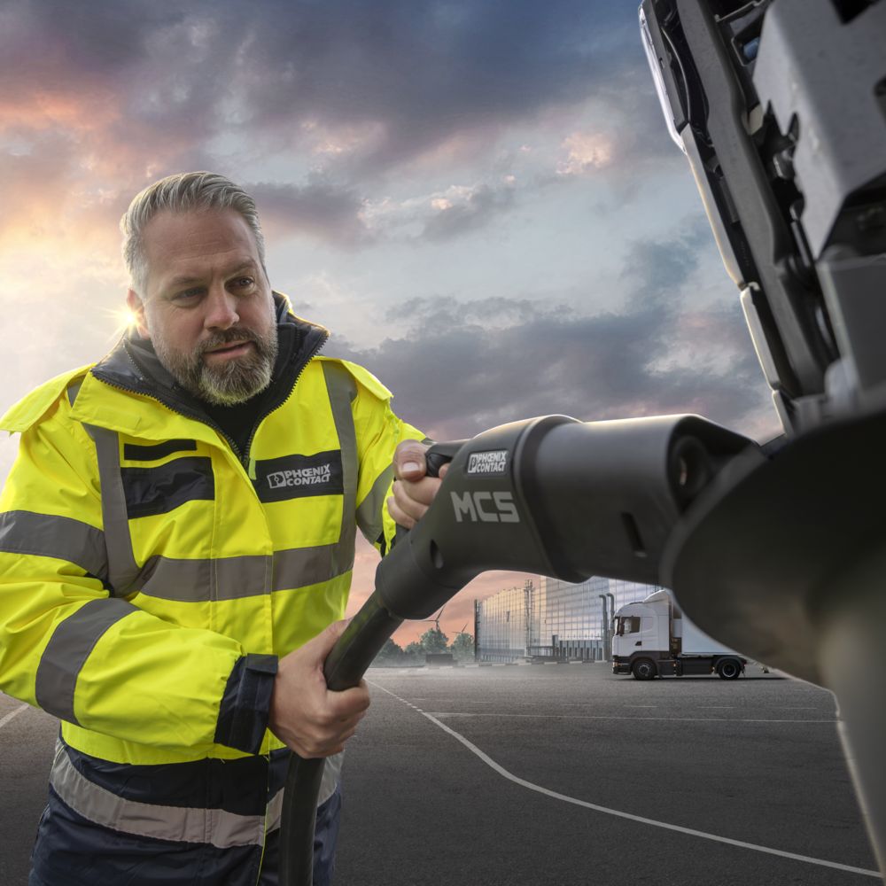 Truck driver charging an electric truck with an MCS charging connector