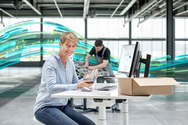 Persoon aan zijn bureau met montagerail in de hand