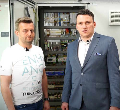 inżynierowie prezentują aplikację kongeneracji na tle szafy sterowniczej