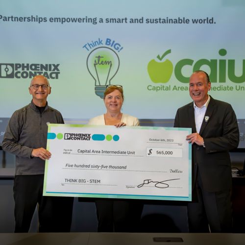 Phoenix Contact leaders from Germany and the U.S. present a giant check to the Capital Area Intermediate Unit