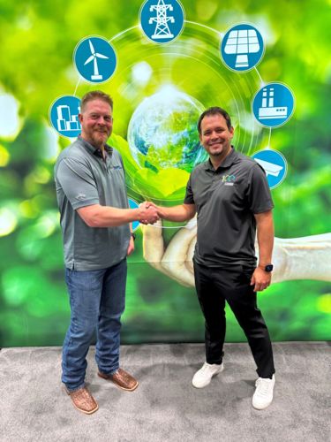 Two men shake hands in front of a wall with an abstract mural featuring a green nature motif with various green energy logos