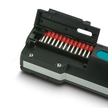 Red insulated ferrules in the open magazine of the portable automatic stripping and crimping device
