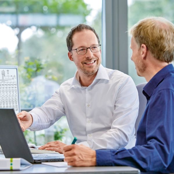 Mitarbeitende arbeiten zusammen am Schreibtisch