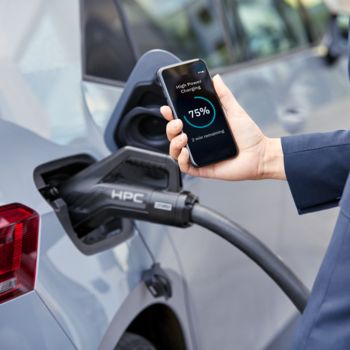 El coche eléctrico se carga a través de la entrada de carga CCS; mientras tanto, el progreso se muestra en un smartphone
